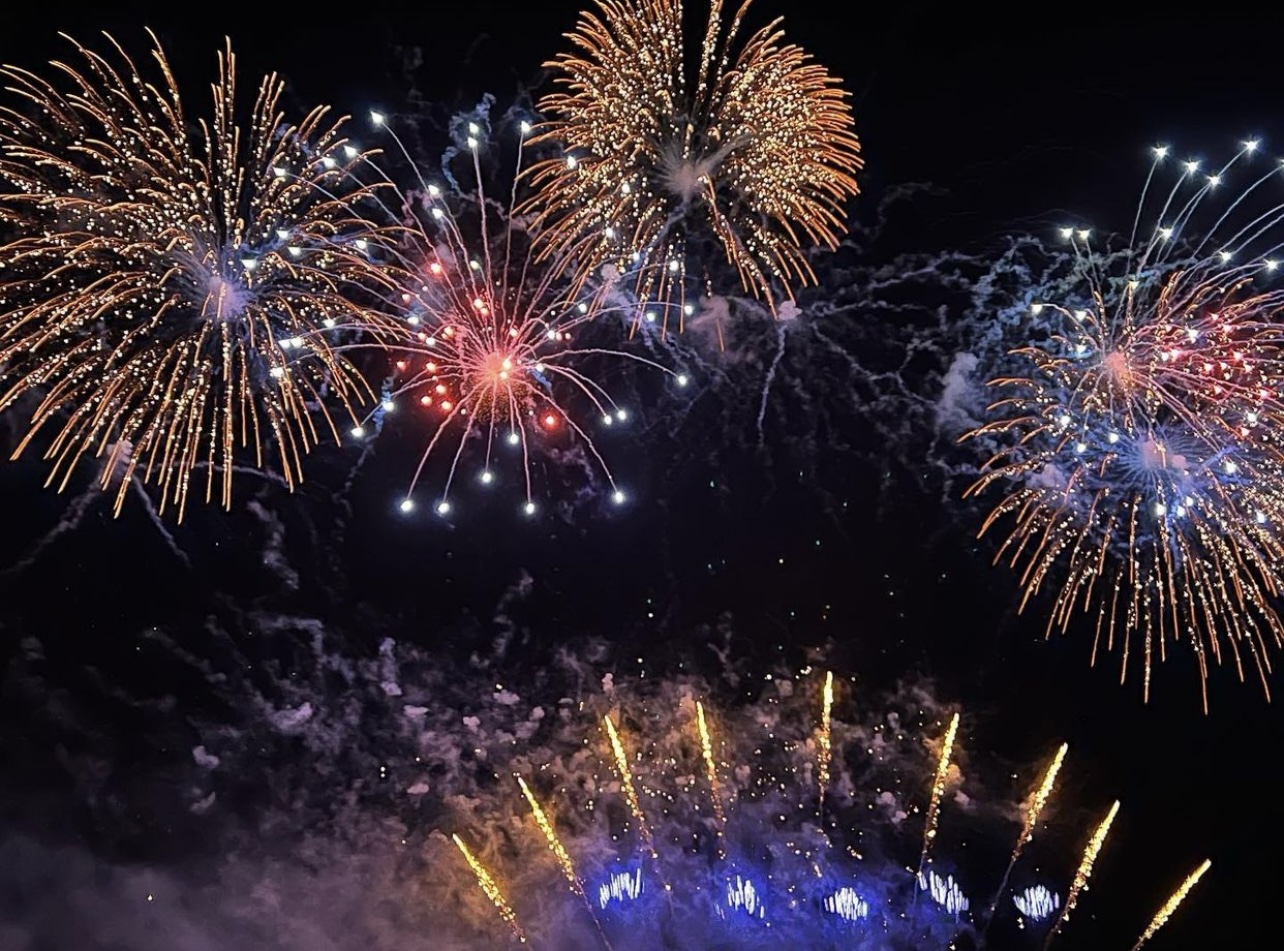 Family audience in awe beneath glowing fireworks