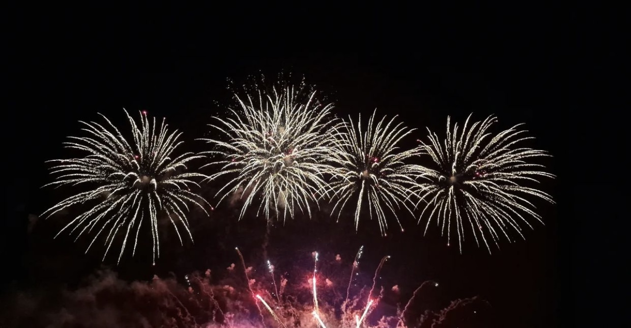 White and emerald firework bursts in the night